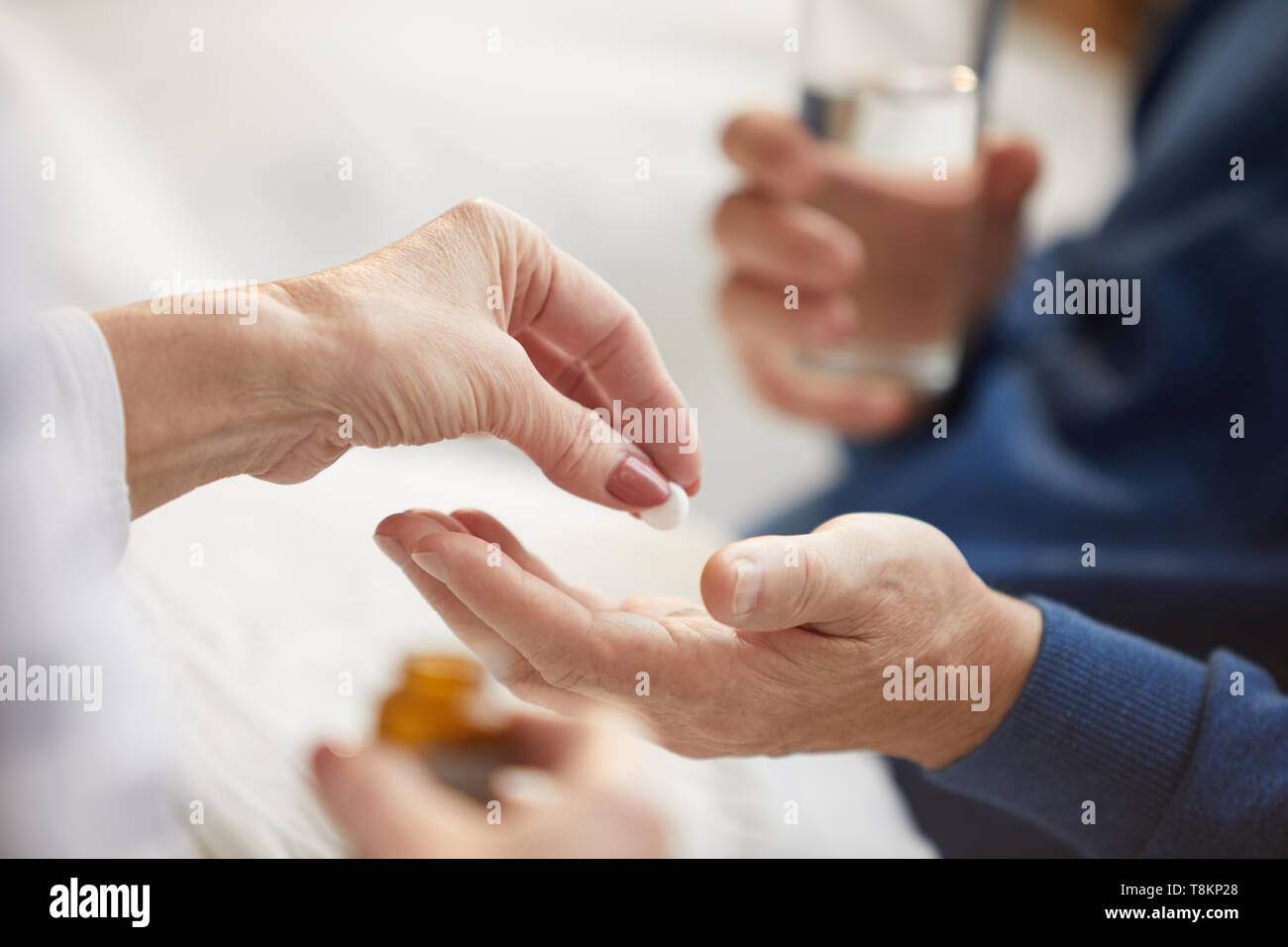 Giving Pills to Senior Man Stock Photo