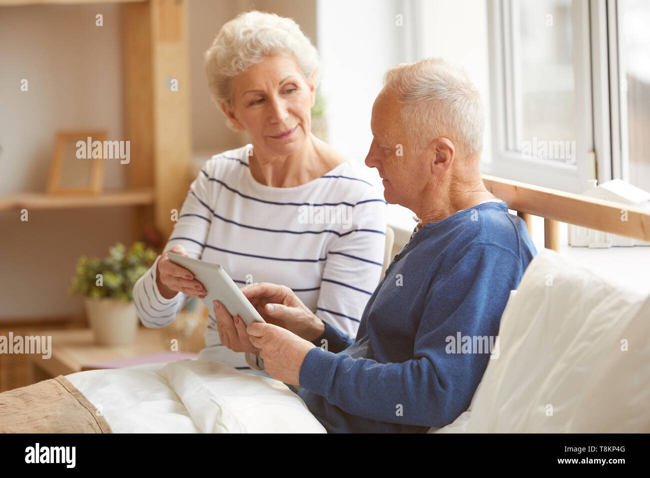 Modern Senior Couple Using Tablet Stock Photo