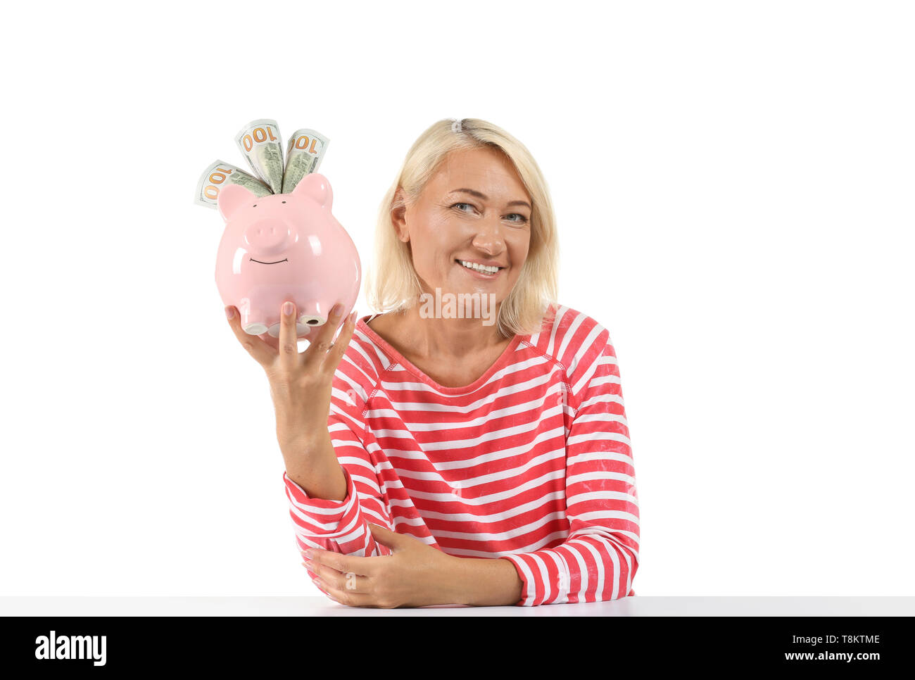 Mature woman with piggy bank on white background Stock Photo - Alamy