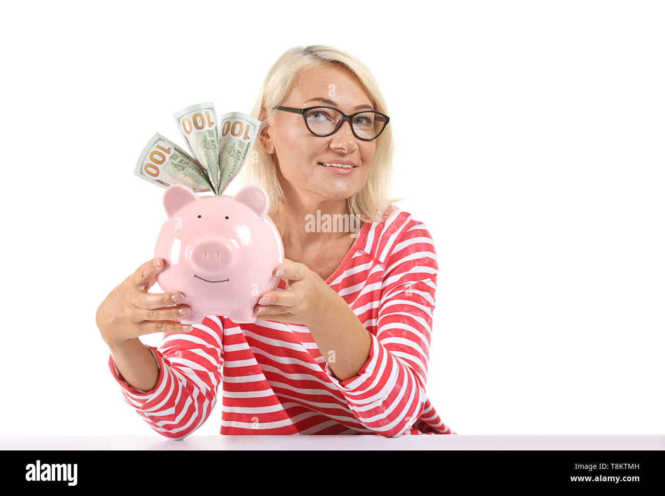 Mature woman with piggy bank on white background Stock Photo - Alamy
