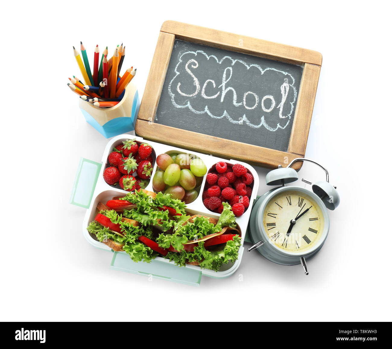 Appetizing food in lunch box and small chalkboard with word SCHOOL on ...