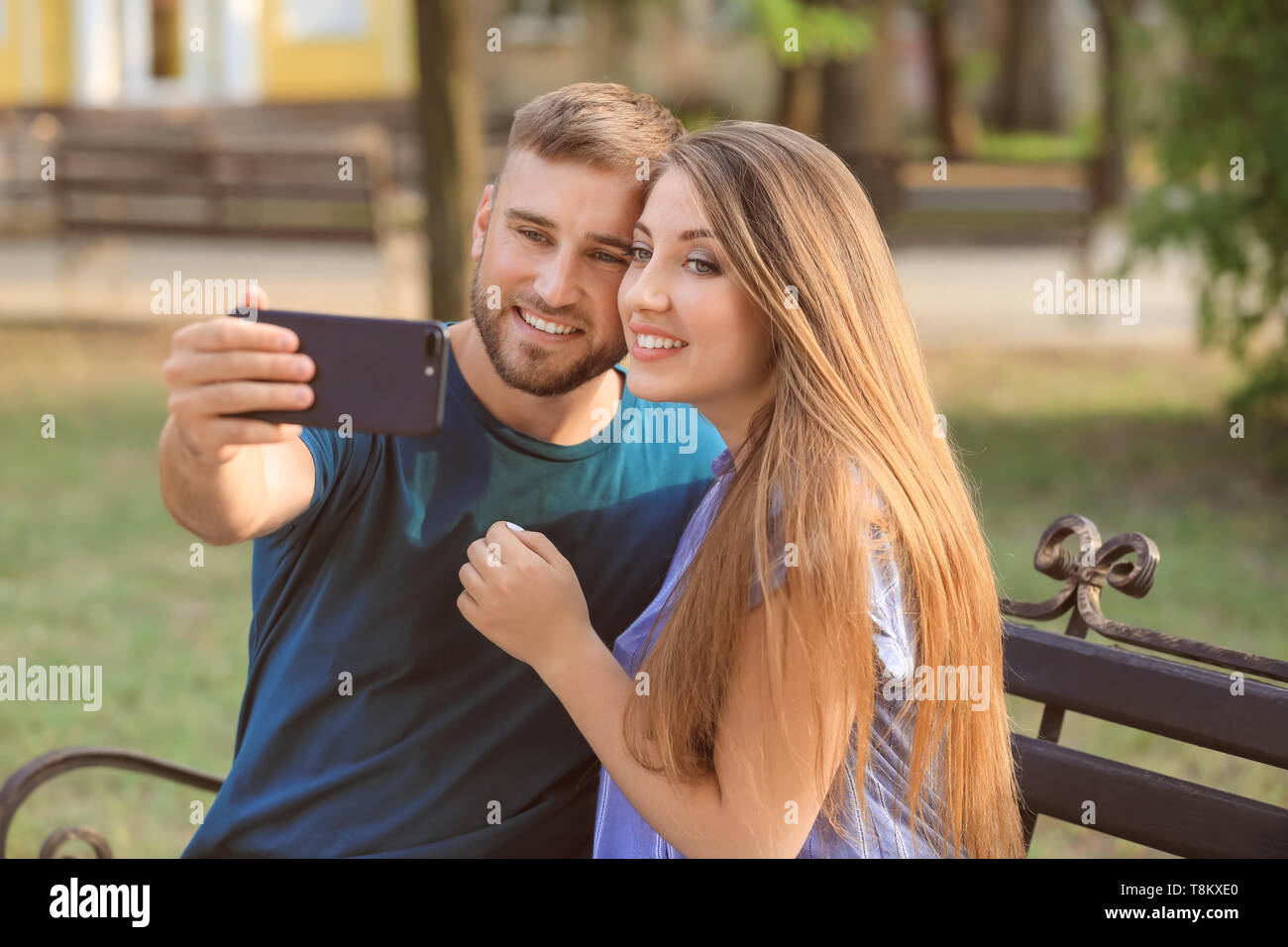 Happy loving couple taking selfie in park Stock Photo - Alamy