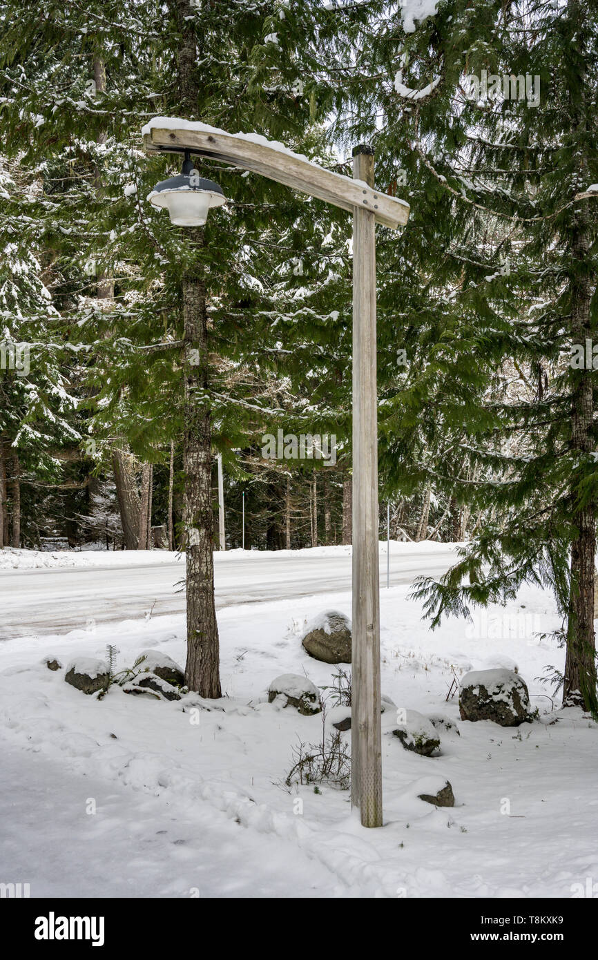 Wooden Lamp Post in the Snow along a snowy road Stock Photo