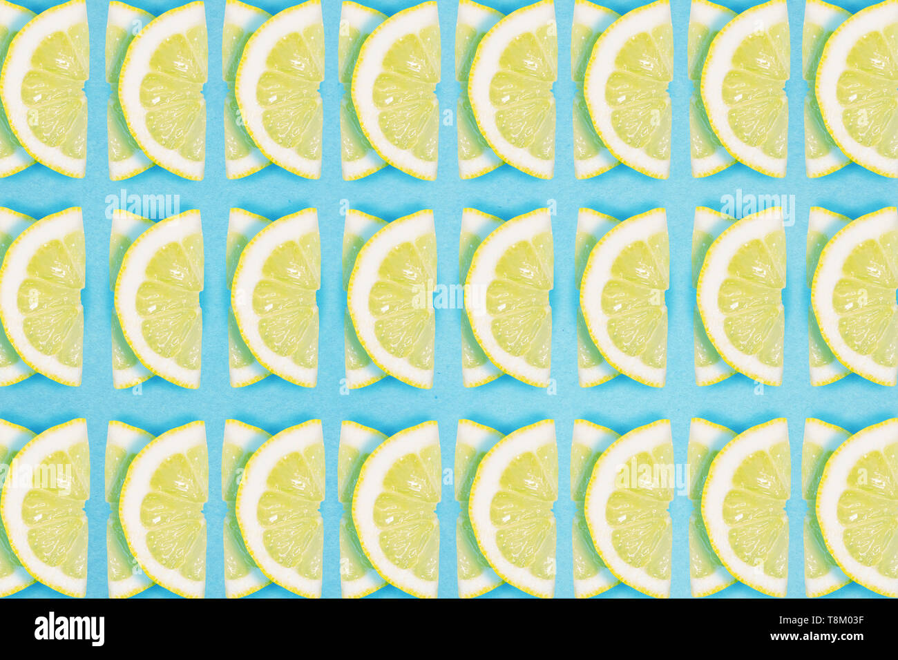 Bright lemon repeat pattern on a blue background. Flat lay summer concept. Stock Photo