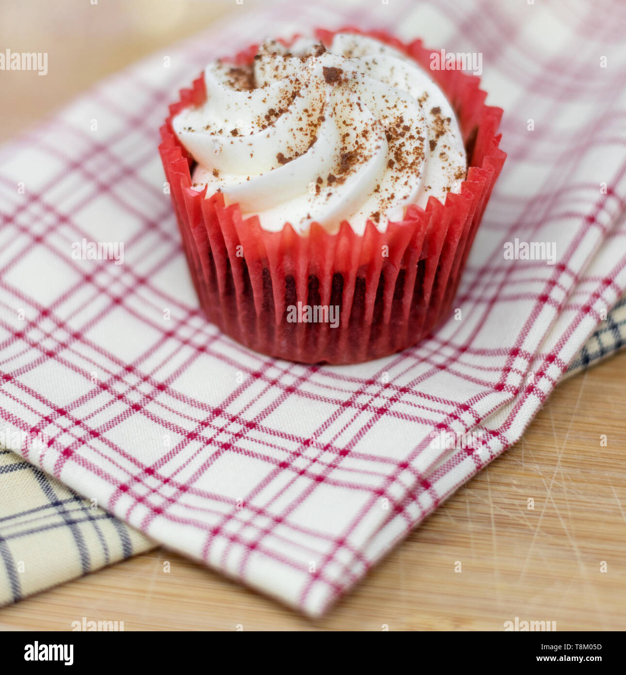Red velvet cupcake on decorative plaid cloth with a shallow depth of field Stock Photo