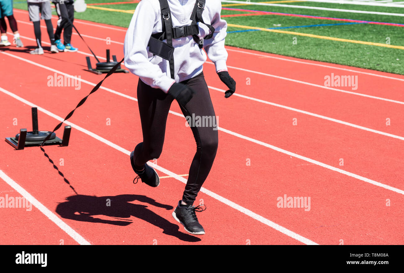 Runners Sprinters On A Boys And Girls High School Track And Field Team Run While Pulling A Sled With Weights On It On A Track Stock Photo Alamy
