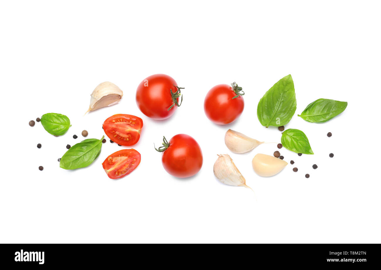 Delicious tomatoes with fresh basil and spices on white background ...