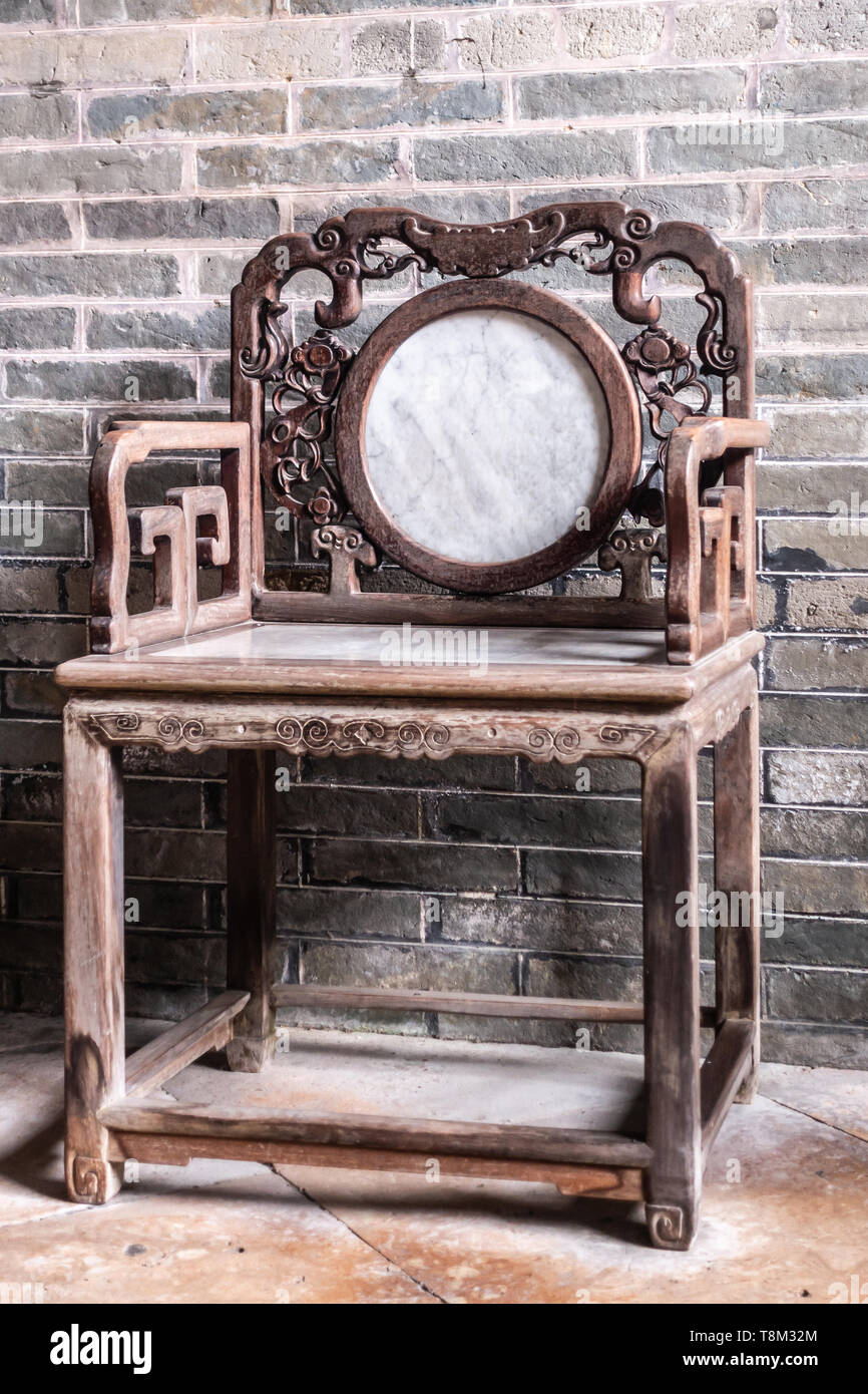 Hong Kong, China - March 8, 2019: Tai Fu Tai Ancestral home in New Territory. Antique wooden chair with white marble back and seat. Stock Photo