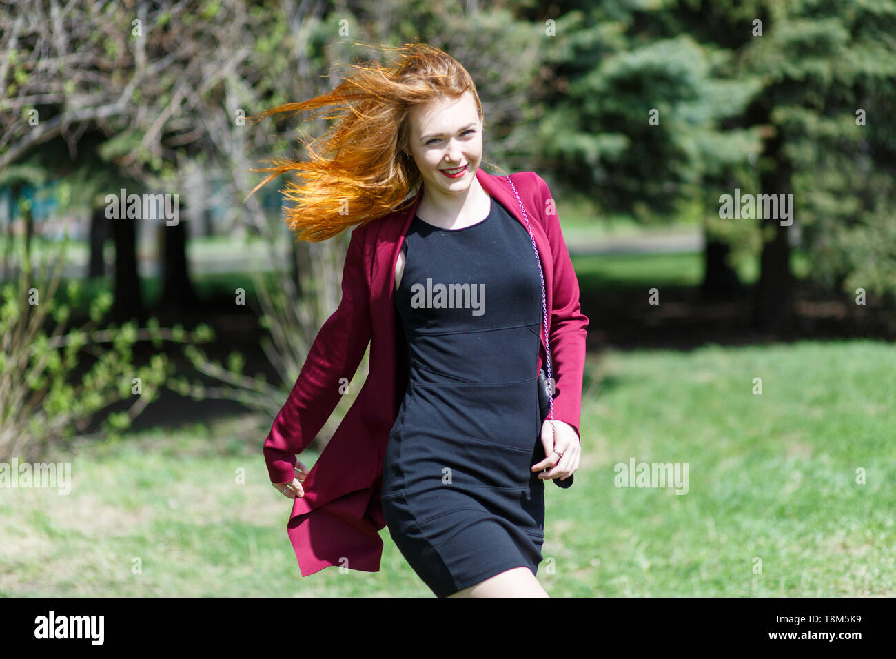 Happy girl with red hair walking in the Park Stock Photo - Alamy