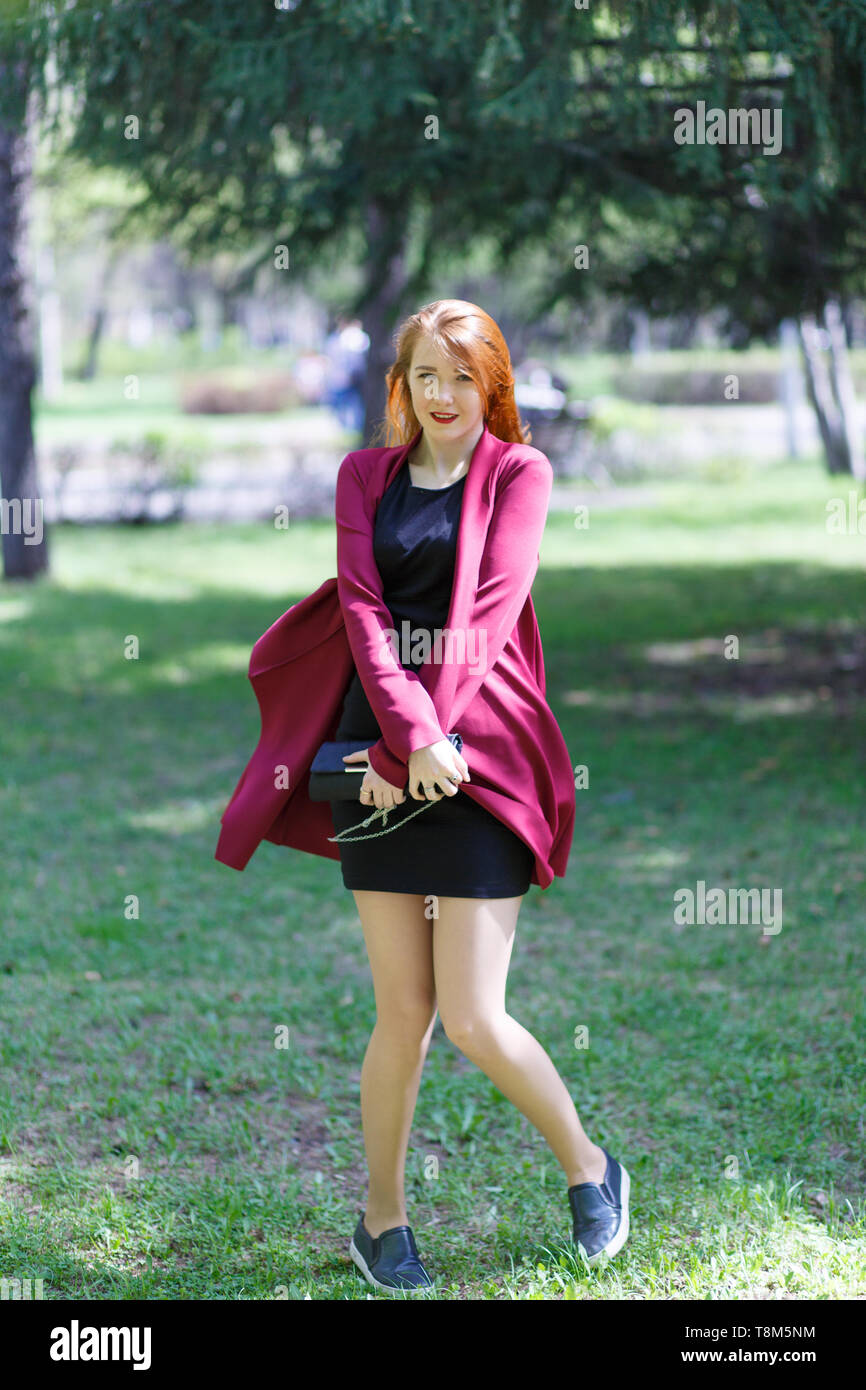 Happy girl with red hair walking in the Park Stock Photo - Alamy