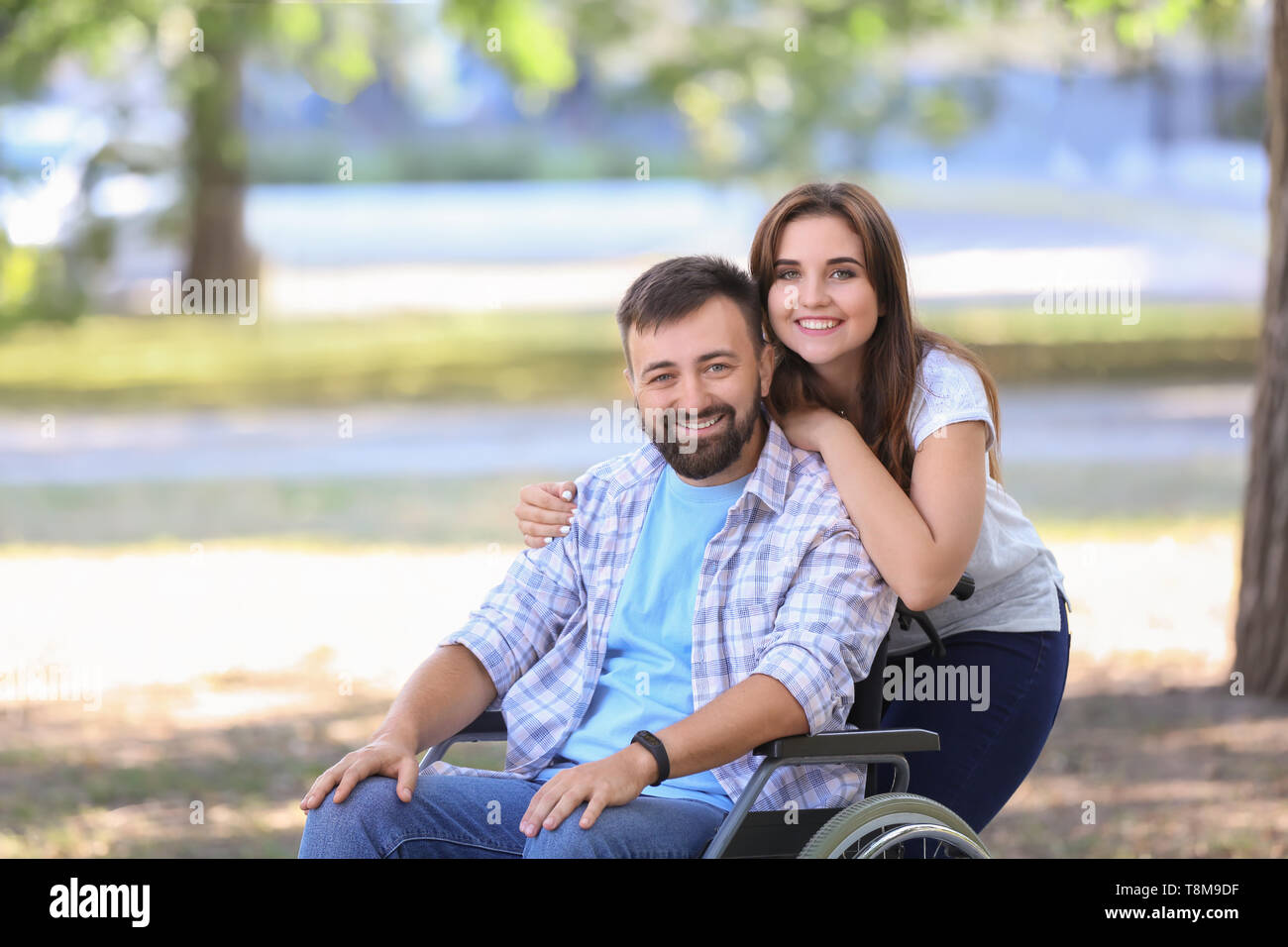 Young man in wheelchair with his wife outdoors Stock Photo Alamy