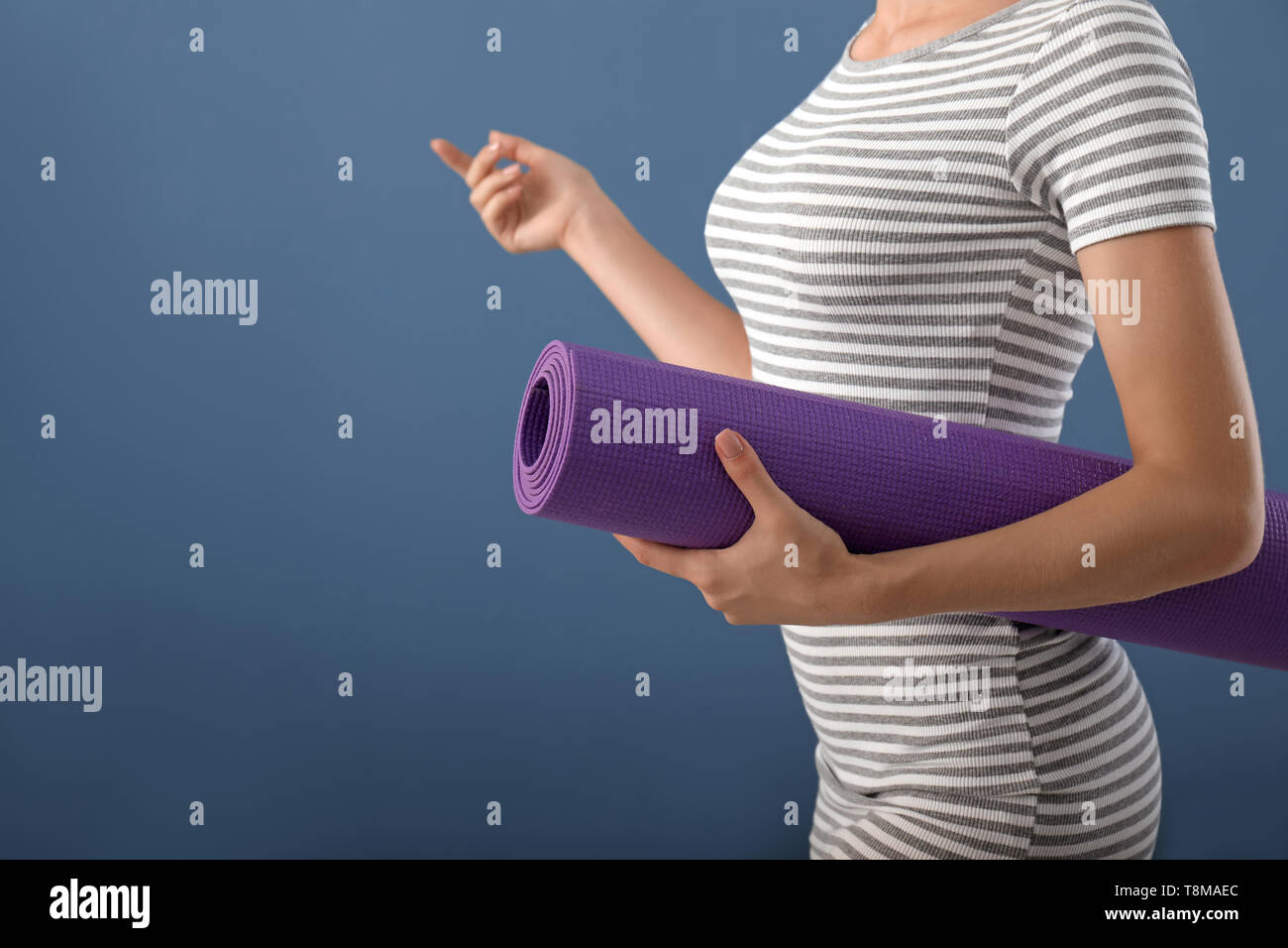 Young woman with yoga mat on color background Stock Photo - Alamy