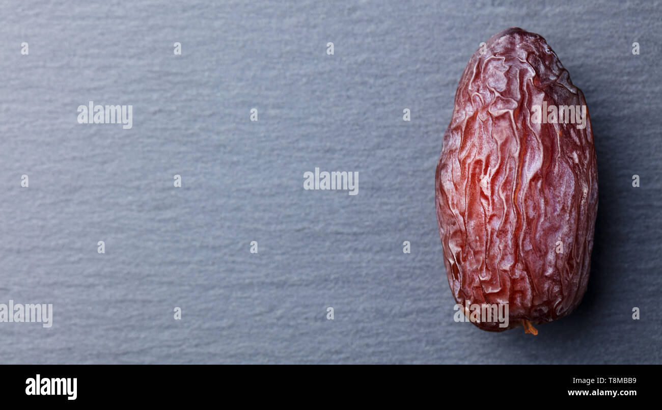 Fresh Medjool Dates. Slate stone background. Top view. Copy space. Stock Photo