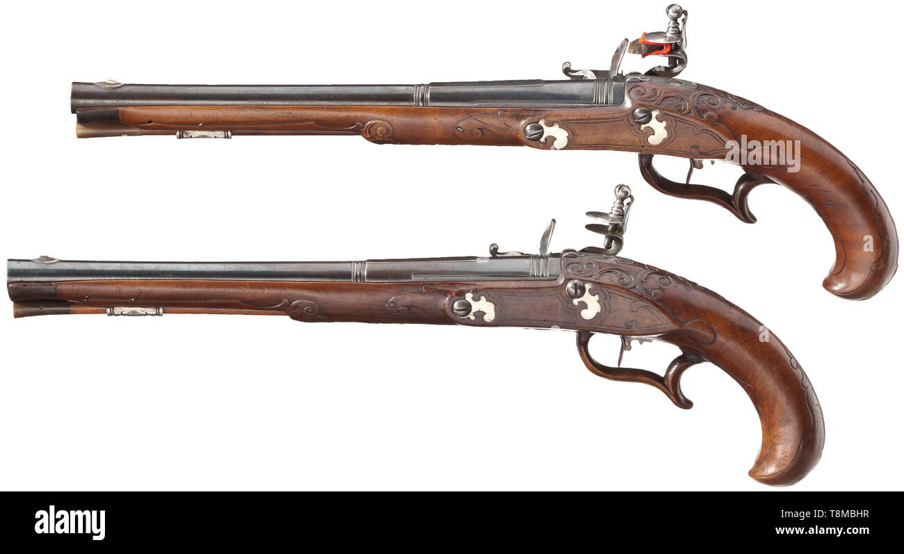 A pair of flintlock pistols, Andreas Gans in Augsburg, circa 1740 Burnished, smooth barrels, segmented by girdles, with slightly swamped muzzles in 12 mm calibre. Sparsely chiselled flintlocks, the lock plates signed and engraved with a civic coat of arms. Finely carved full stocks with reduced, silver furniture and nosepieces made from horn. Wooden ramrods with horn tips. With professional repairs, one forestock with a small crack. Length 43 cm. historic, historical, civil handgun, civil handguns, handheld, gun, guns, firearm, fire arm, firearms, Additional-Rights-Clearance-Info-Not-Available Stock Photo