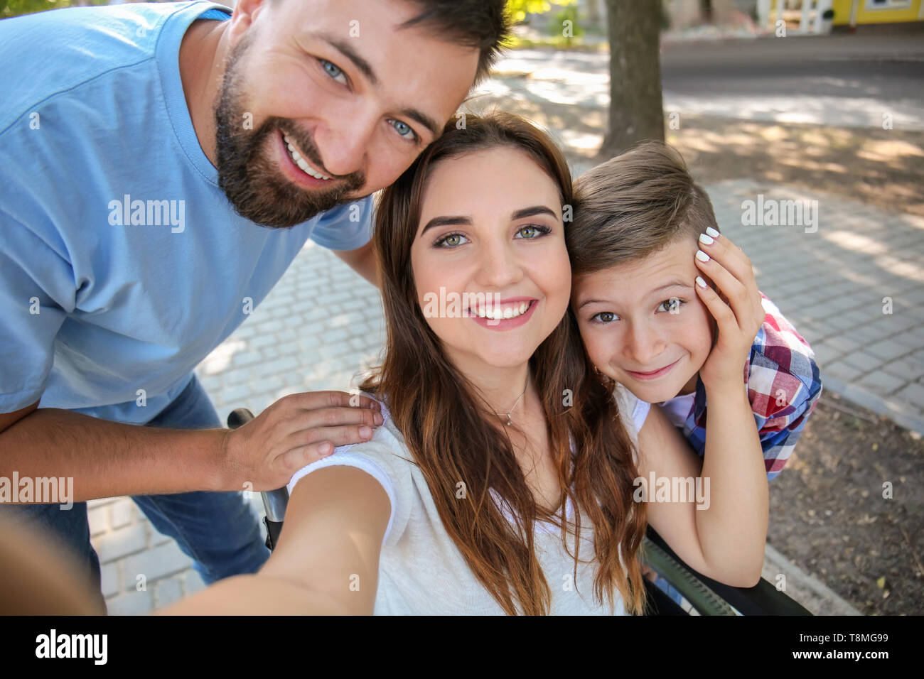 Young woman in wheelchair with her family taking selfie outdoors Stock ...