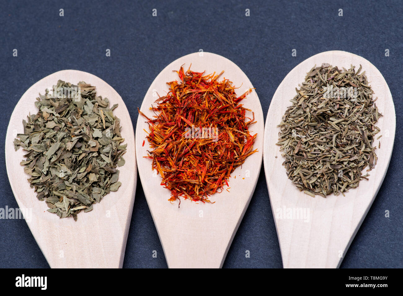 Collection of Spices in wooden spoons (Basil, Saffron, Thyme) on dark background Stock Photo Alamy