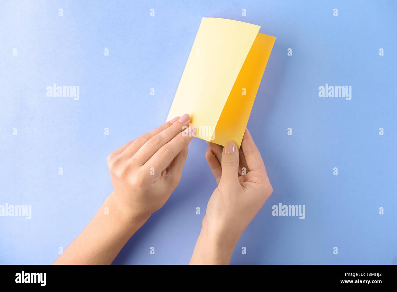 Woman making origami boat on color background Stock Photo