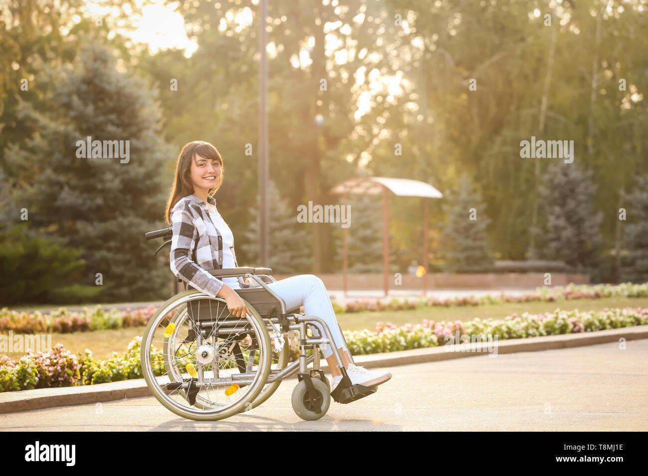 Happy young woman in wheelchair outdoors Stock Photo - Alamy