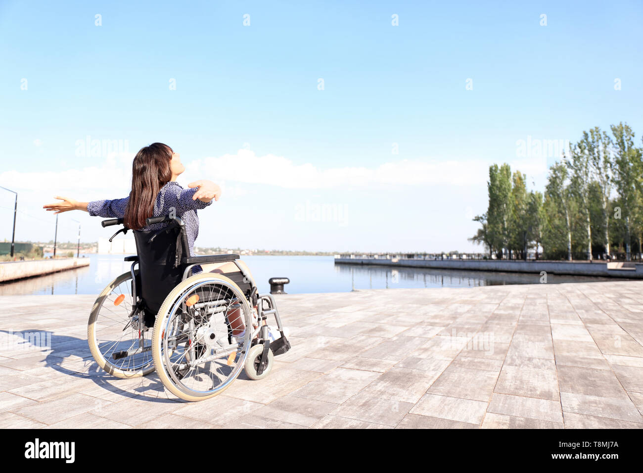Happy young woman in wheelchair outdoors Stock Photo - Alamy