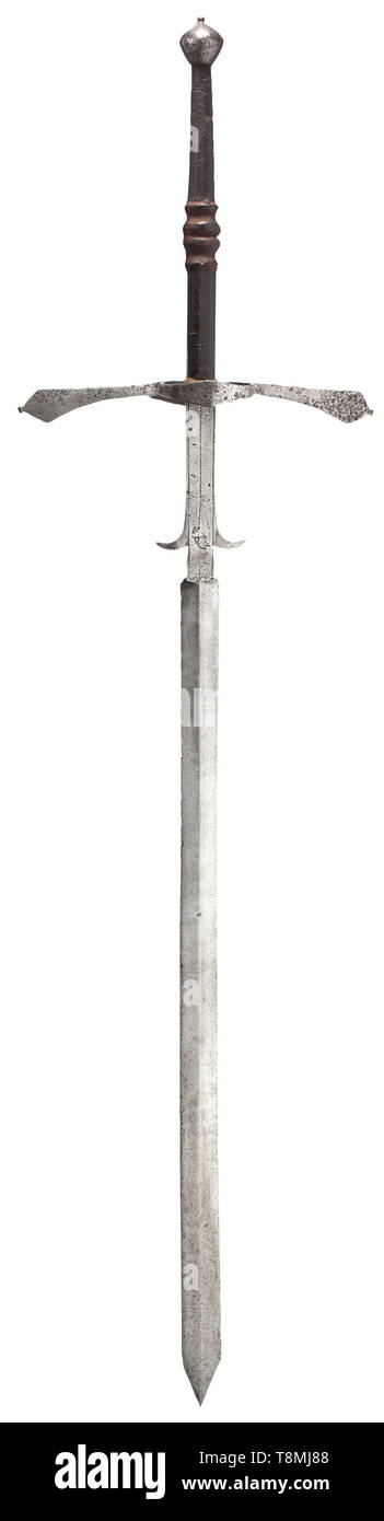 A South German two-hand sword, circa 1580 Broad, double-edged blade with a medial ridge on each side. Long ricasso with decorative lines and lugs separated on the sides. Extended quillons conically widening towards the ends, guard rings on both sides with mounted guard plates. Octagonal grip with central baluster, the original leather cover with grooved decoration is largely preserved. Round, double-tapering pommel. Length 165 cm. historic, historical, sword, swords, weapons, arms, weapon, arm, fighting device, military, militaria, object, object, Additional-Rights-Clearance-Info-Not-Available Stock Photo