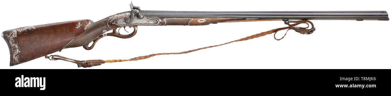 A double-barrelled percussion shotgun, Blasius Sailer in Ehingen, circa 1820 Smooth two-stage barrels in 15.5 mm calibre, octagonal then round, the front half attached. The midrib with silver-inlaid tendrils, the tops of the barrels with motto (tr.) 'I am a hunter, in the distance I stand and I like shooting foxes and birds'. Converted percussion locks. Half stock with typical, lavish silver inlays (some are missing) and finely engraved, iron furniture. Later wooden ramrod with horn tip. Traces of age and use, the stock with cracks and repairs. L, Additional-Rights-Clearance-Info-Not-Available Stock Photo