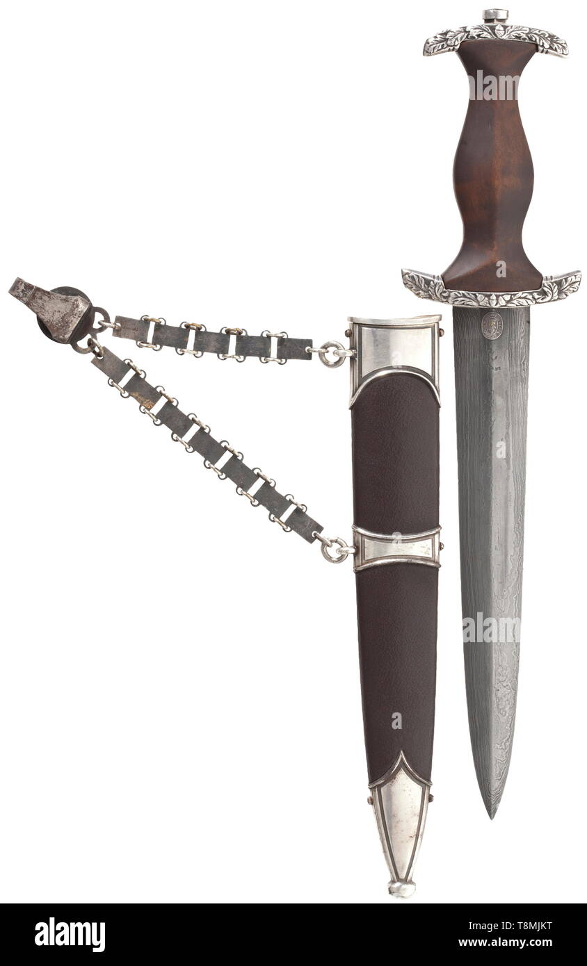 An SA honour dagger M 38 for senior leaders, with damascus blade and chain hanger, by Eickhorn, Solingen Damascus blade with raised, gilt motto 'Alles für Deutschland' between oak leaf branches, maker's mark 'Original Eickhorn Solingen', struck 'Damast' and '248' in the tang. Silver cross guard with oak leaf décor in relief, brown wooden grip with applied fine German silver eagle and enamelled SA medallion. The scabbard with brown leather cover. Iron chain hanger with silvered scabbard fittings. Length 34.5 cm. These daggers were bestowed by Viktor Lutze on deserving SA sen, Editorial-Use-Only Stock Photo