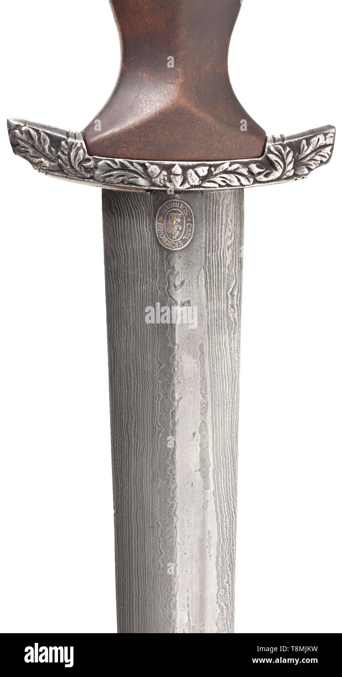 An SA honour dagger M 38 for senior leaders, with damascus blade and chain hanger, by Eickhorn, Solingen Damascus blade with raised, gilt motto 'Alles für Deutschland' between oak leaf branches, maker's mark 'Original Eickhorn Solingen', struck 'Damast' and '248' in the tang. Silver cross guard with oak leaf décor in relief, brown wooden grip with applied fine German silver eagle and enamelled SA medallion. The scabbard with brown leather cover. Iron chain hanger with silvered scabbard fittings. Length 34.5 cm. These daggers were bestowed by Viktor Lutze on deserving SA sen, Editorial-Use-Only Stock Photo
