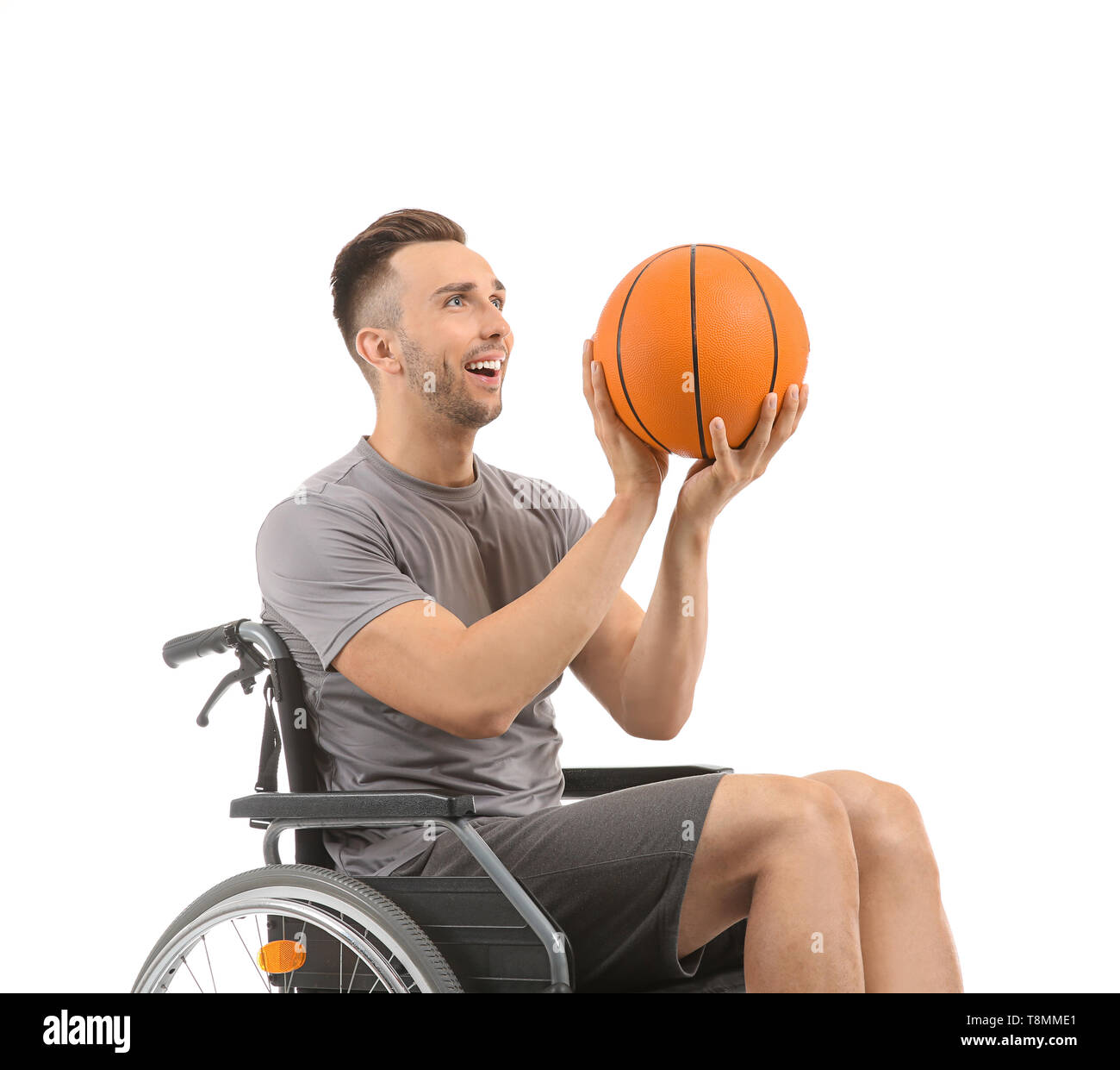 Young basketball player sitting in wheelchair on white background Stock Photo
