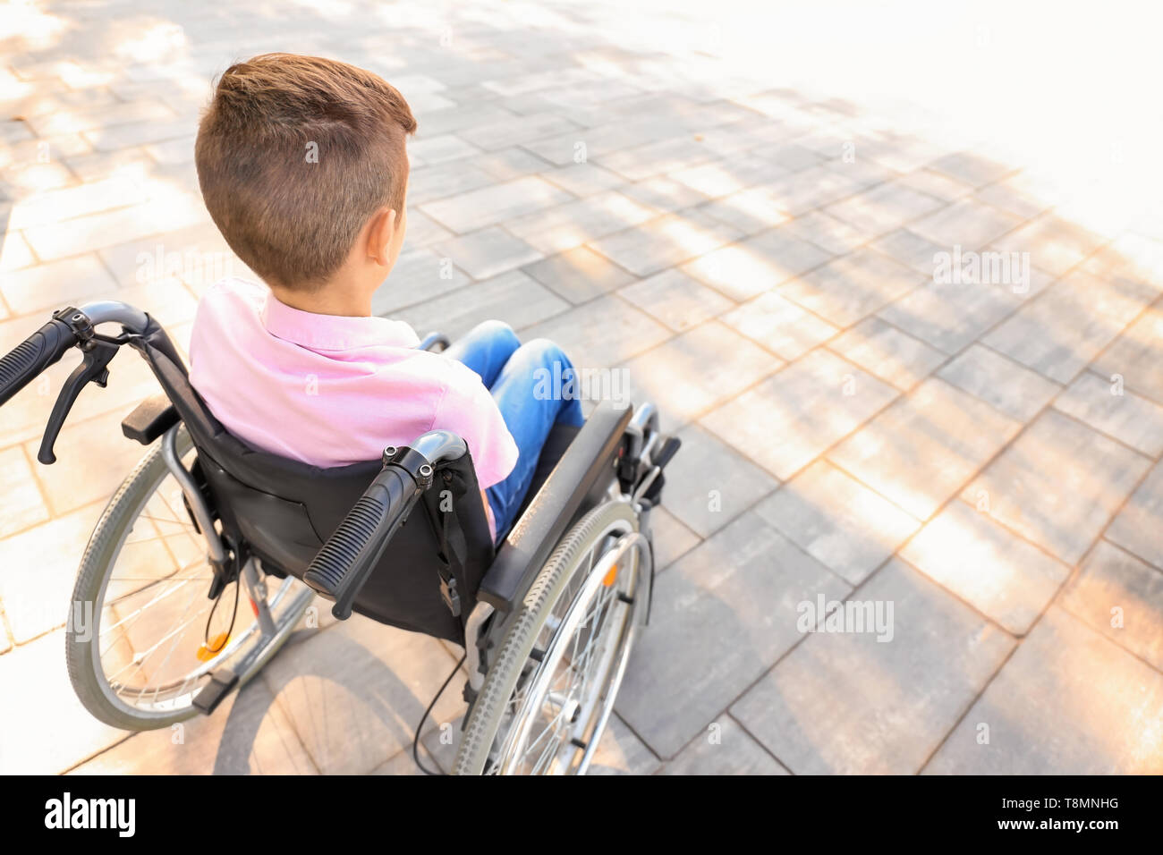 Boy in wheelchair outdoors Stock Photo