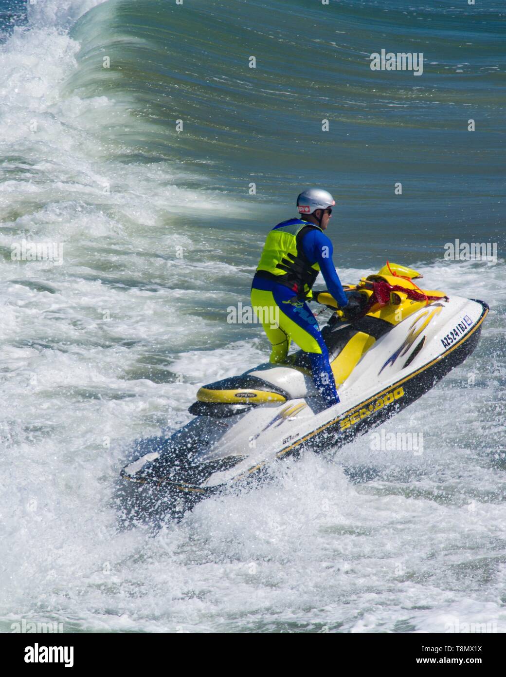Huntington Beach, CA - April 7 2019: Jet skier riding the surf in a dramatic image. Stock Photo