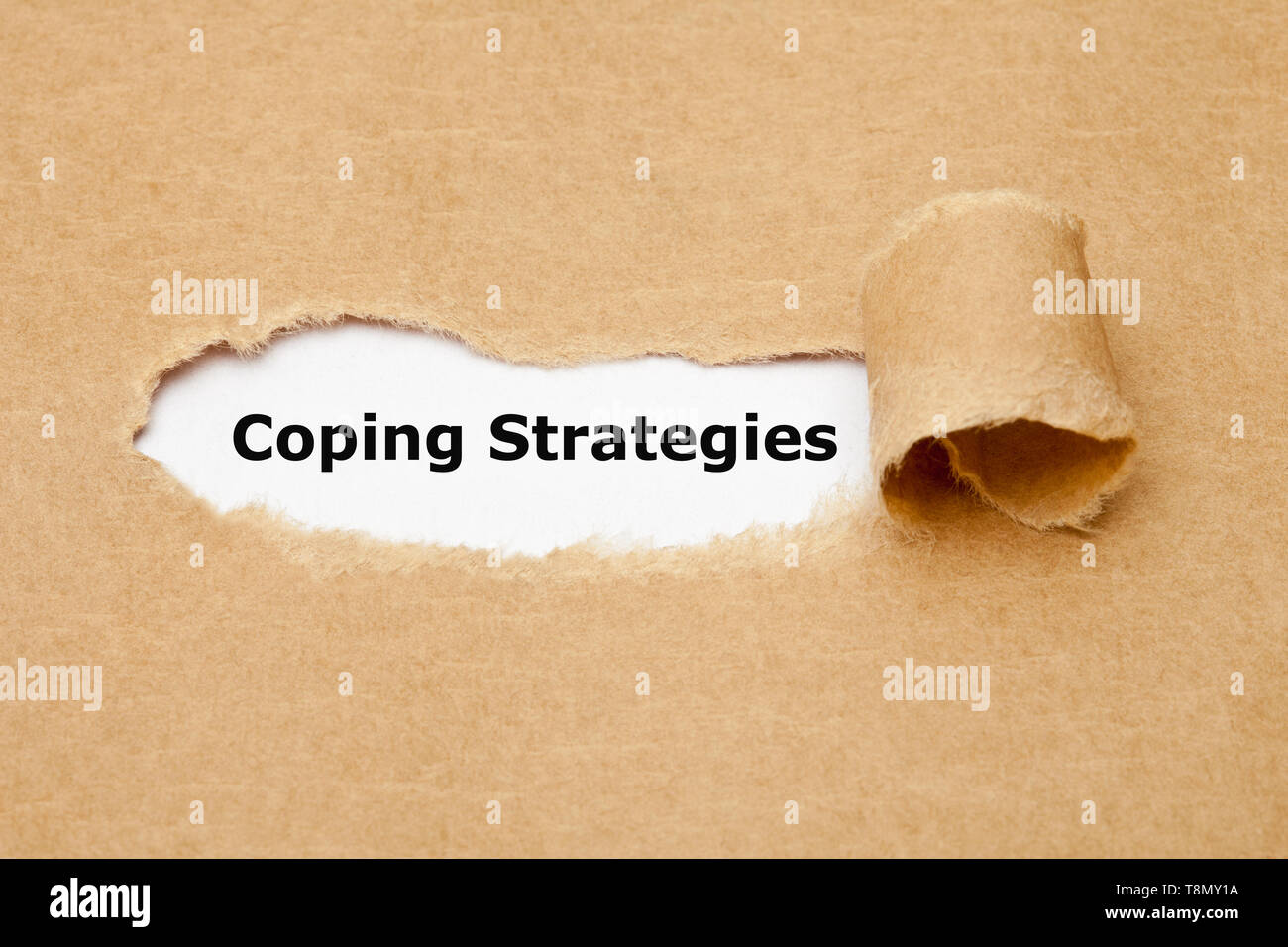 Text Coping Strategies appearing behind ripped paper. Concept about the series of behavioral and psychological skills and actions needed to handle str Stock Photo