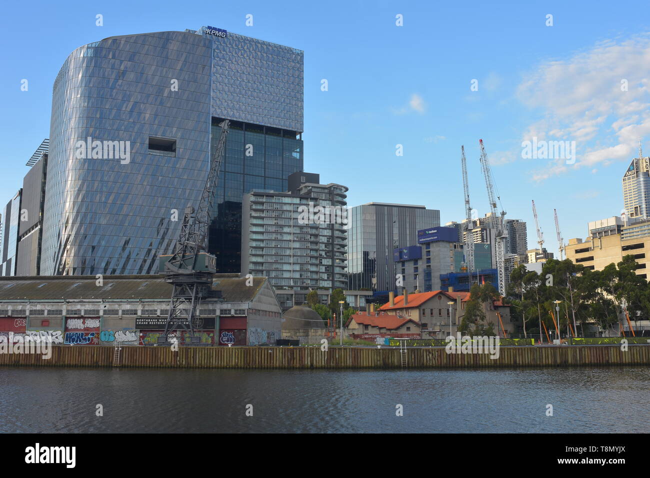 View of northern bank of Yarra River with mix of modern and old both apartment and industrial buildings. Stock Photo