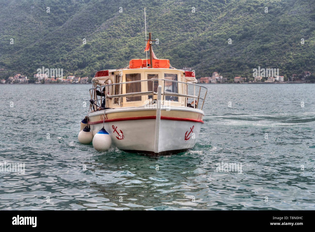 Kotor Bay, Montenegro, May 3rd 2019: A boat with group of tourists approaching the pier in the ancient town of Perast Stock Photo