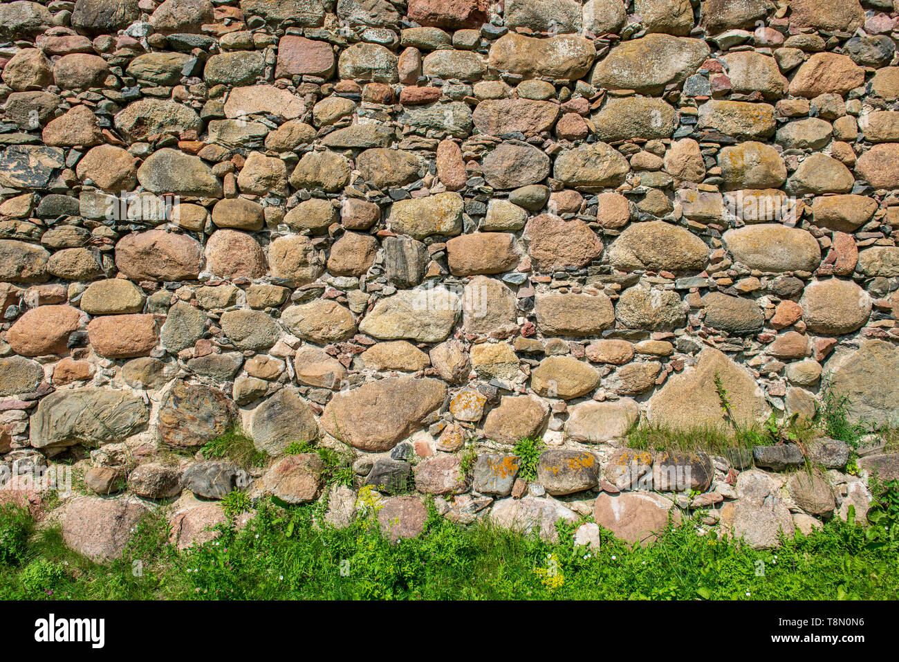 beautiful ancient stone brick wall with green grass below Stock Photo ...