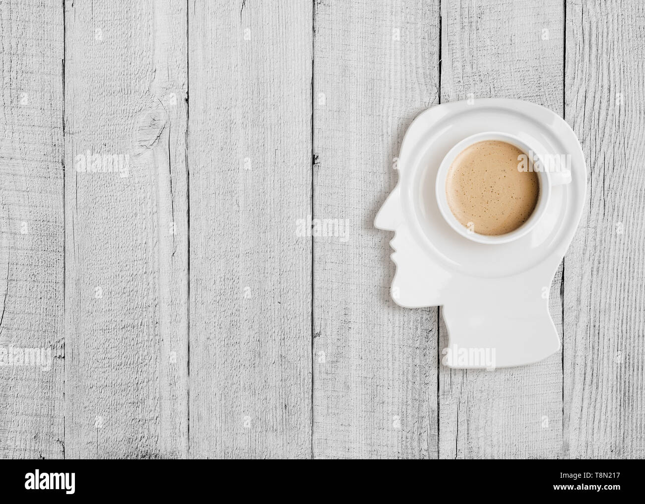 Coffee cup on plate in human head form Stock Photo