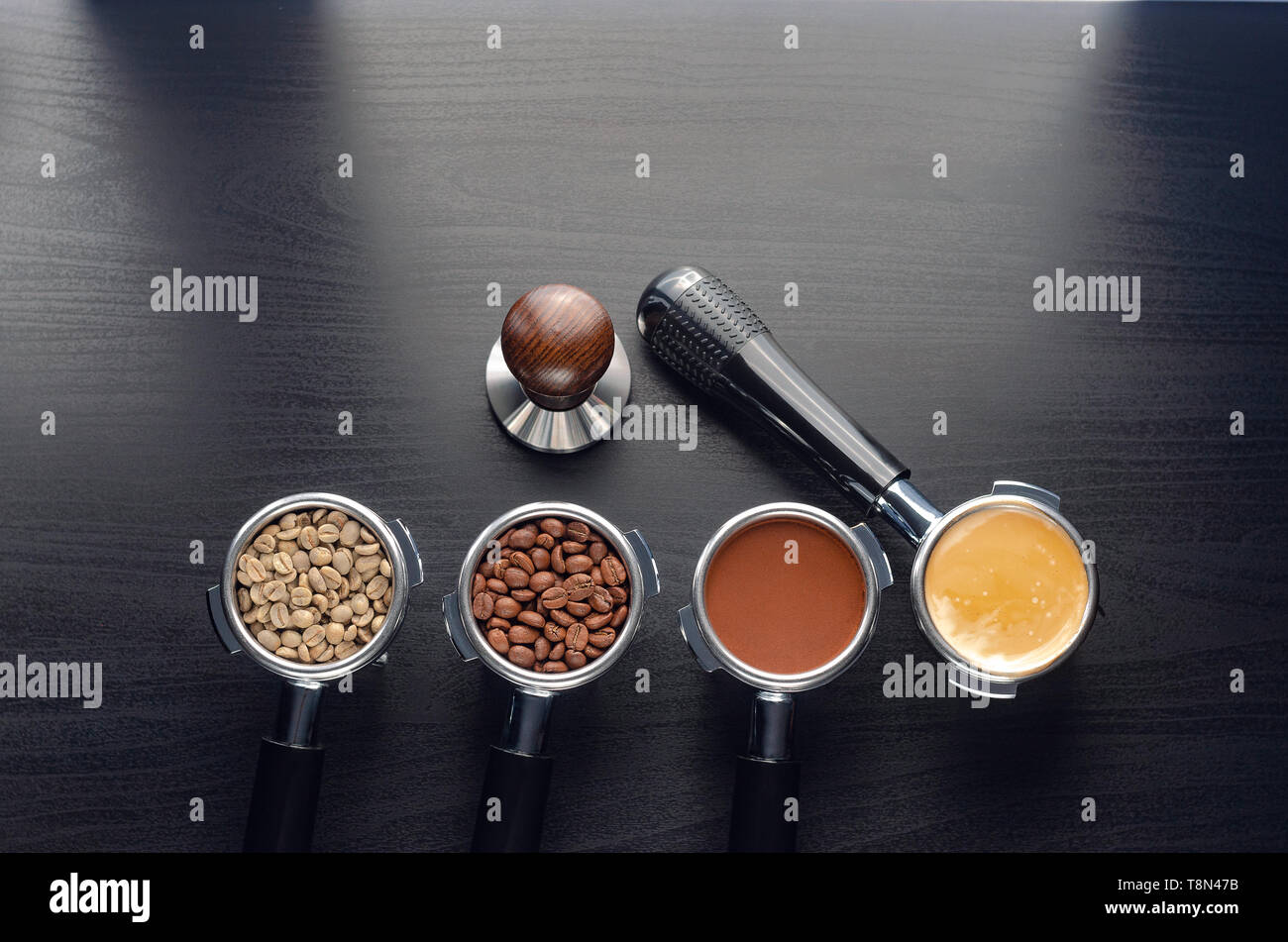 four holders with green, roasted, ground, and hot coffee and tamper