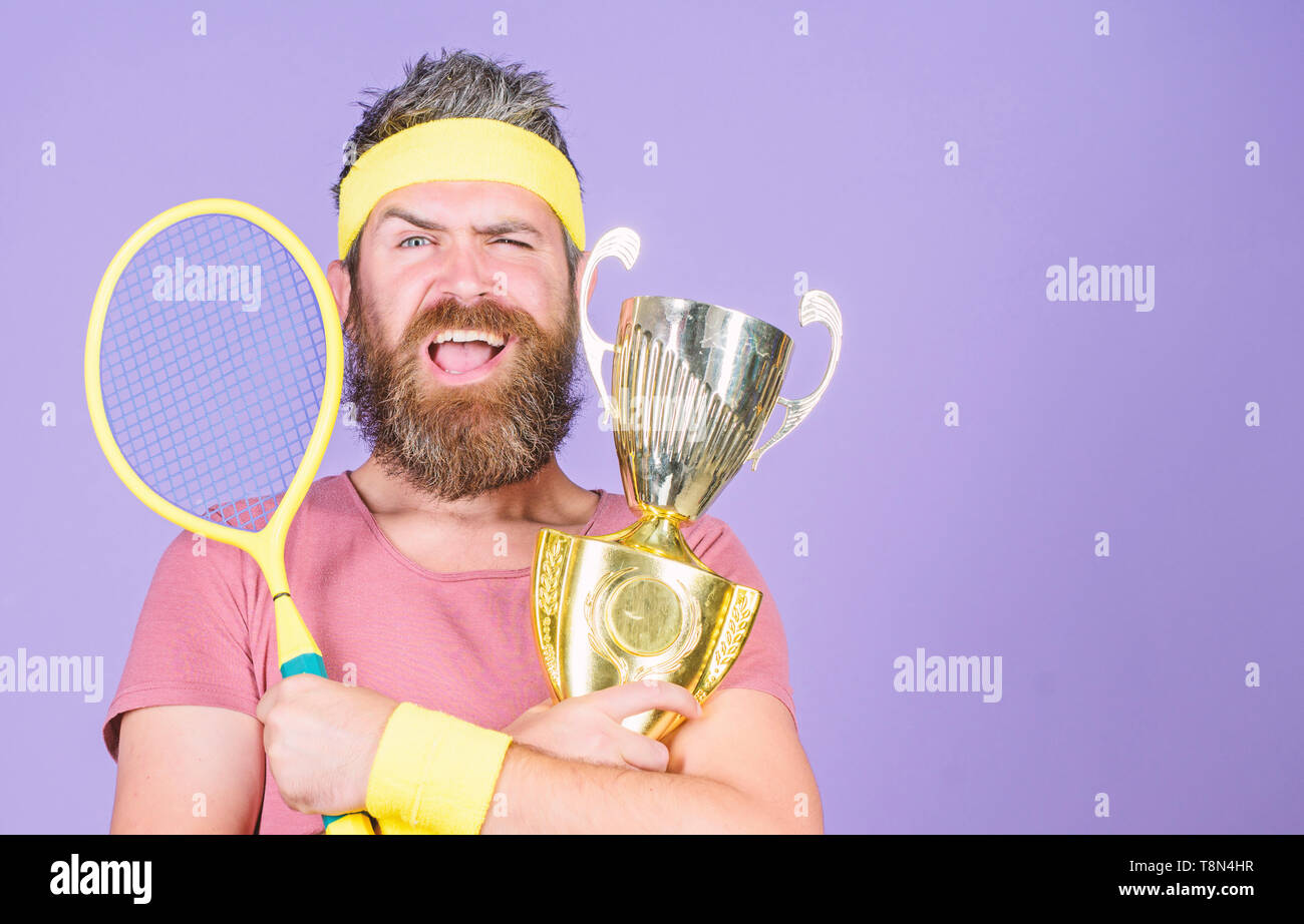 Success and achievement. Win tennis game. Win every tennis match i take  part in. Tennis player win championship. Athlete hold tennis racket and  golden goblet. Man bearded hipster wear sport outfit Stock