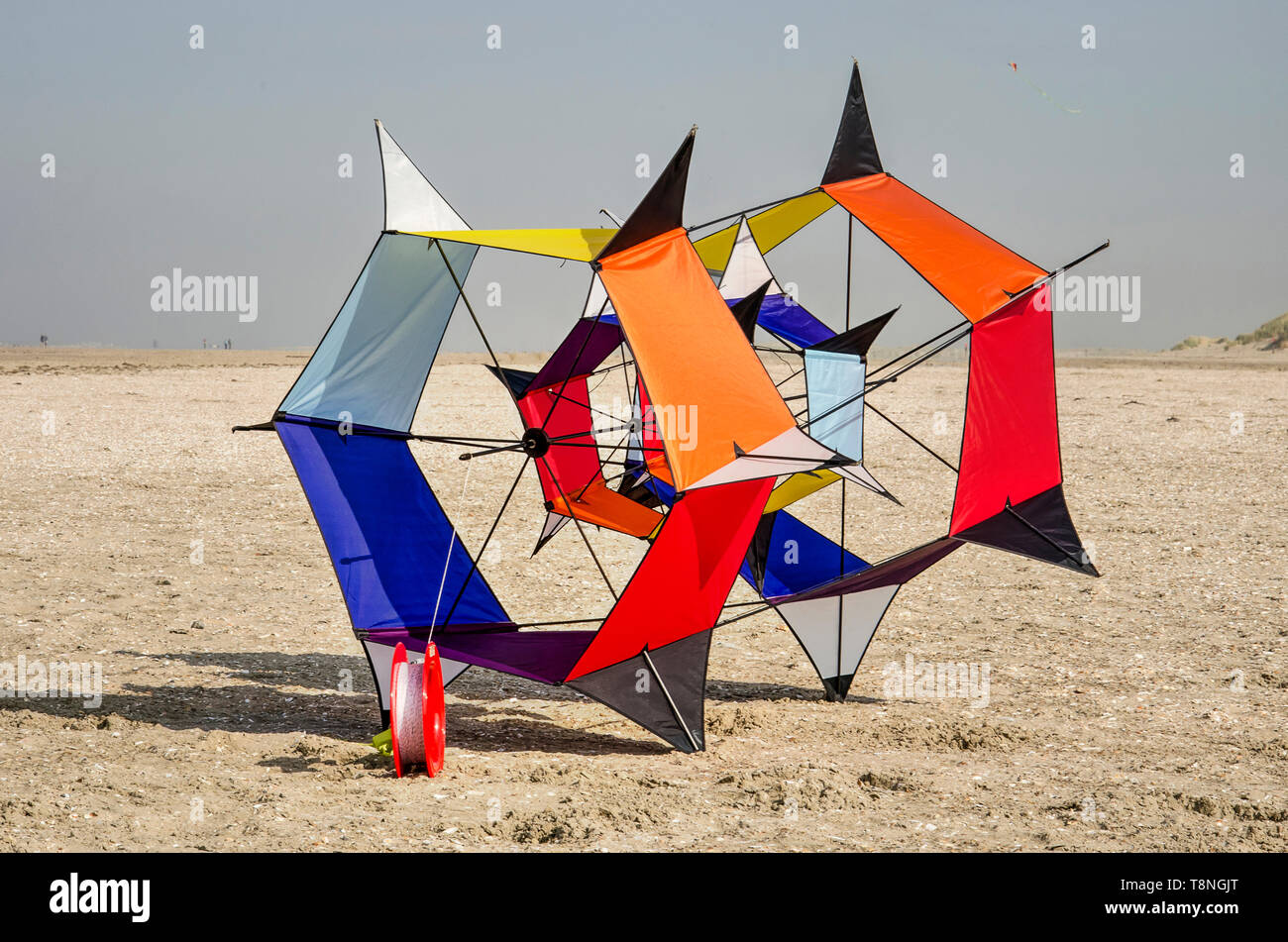 Ouddorp, The Netherlands, October 6, 2018: hexagonally shaped kite with various vibrant colors on the beach with sea and dunes in the background Stock Photo