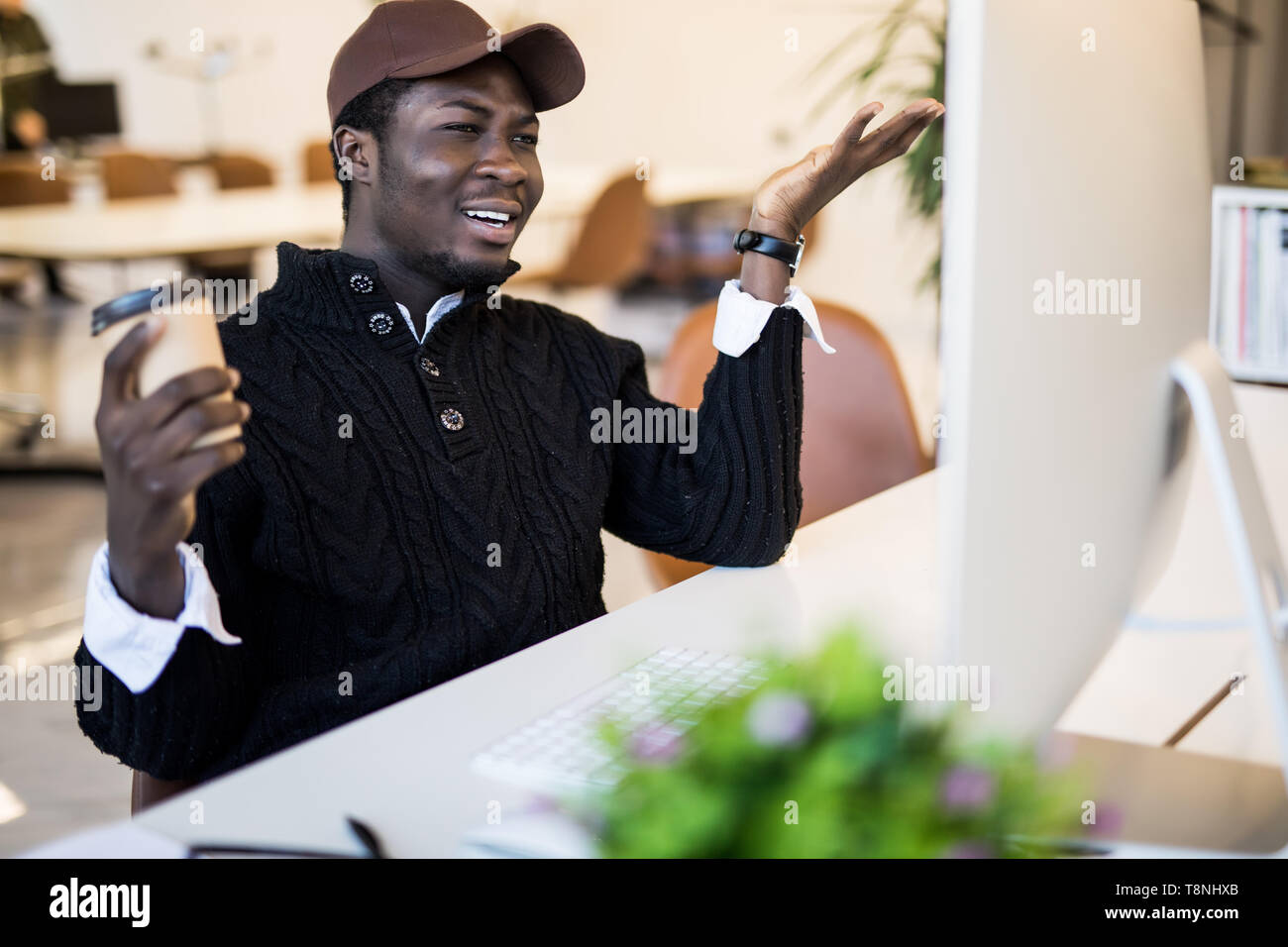 Shocked african businessman in suit feeling stunned by online news looking at computer screen sitting at workplace with laptop, stressed trader invest Stock Photo