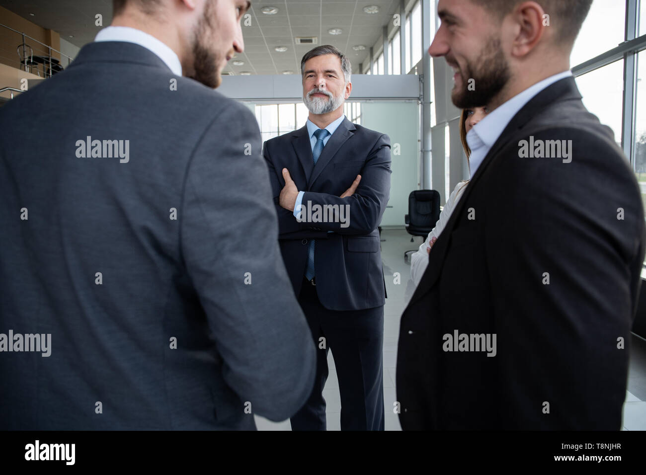 Group of Busy Business People Concept. Business team discussing work in office building hallway. Stock Photo