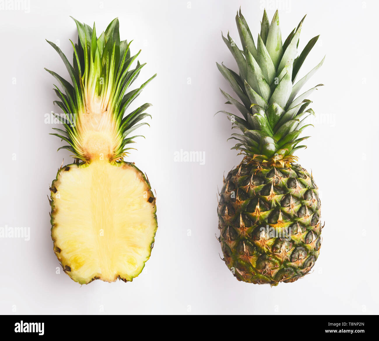 Whole and half pineapple on white Stock Photo