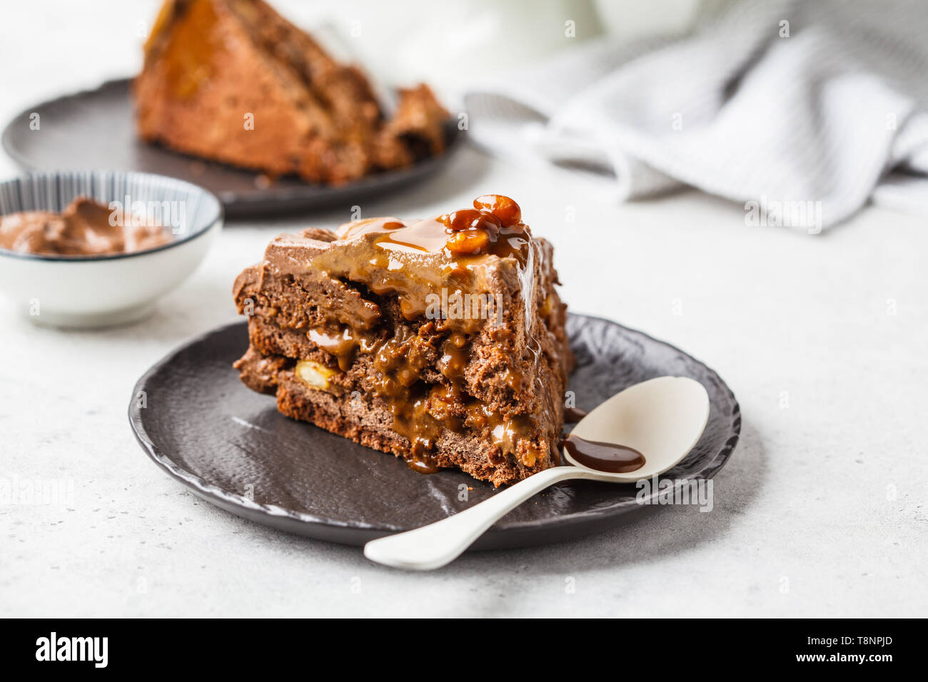 Piece of homemade chocolate cake with chocolate cream on a black saucer ...