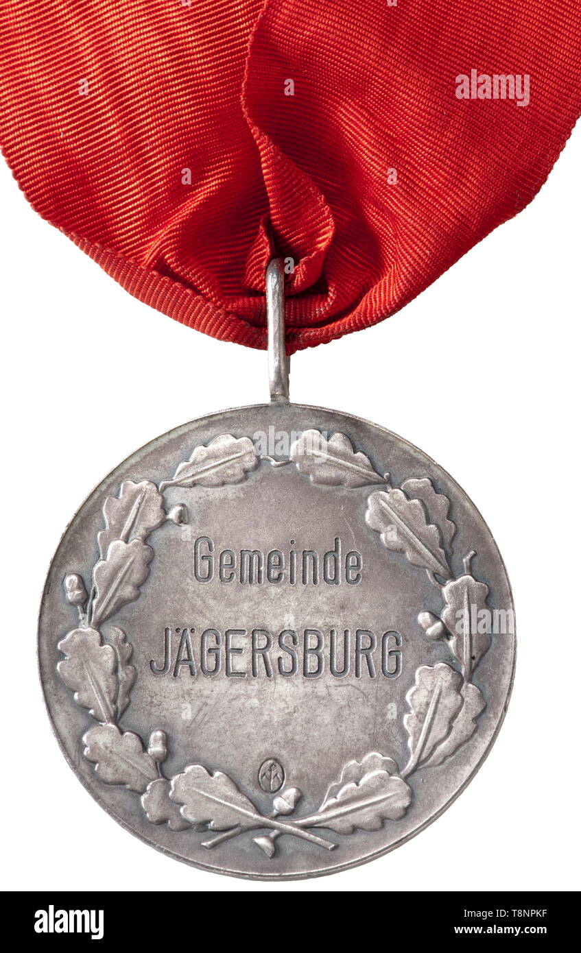A mayor's chain of office of the town of Jägersburg in the district Saarpfalz Silver-plated circular pendant with the name of the town in a raised oak leaf wreath, on the opposite side Hitler's profile portrait in relief with the circumscription 'Der Führer und Reichskanzler Adolf Hitler', maker's mark. On a red, watered silk rep band, with an oversize presentation casket, covered in black leather, lined with green silk and green felt, maker's label 'F. Mannheim, Kaiserslautern'. Dimensions 47 x 33 x 3.5 cm. Extremely rare, prestigious object in exceptionally good condition, Editorial-Use-Only Stock Photo