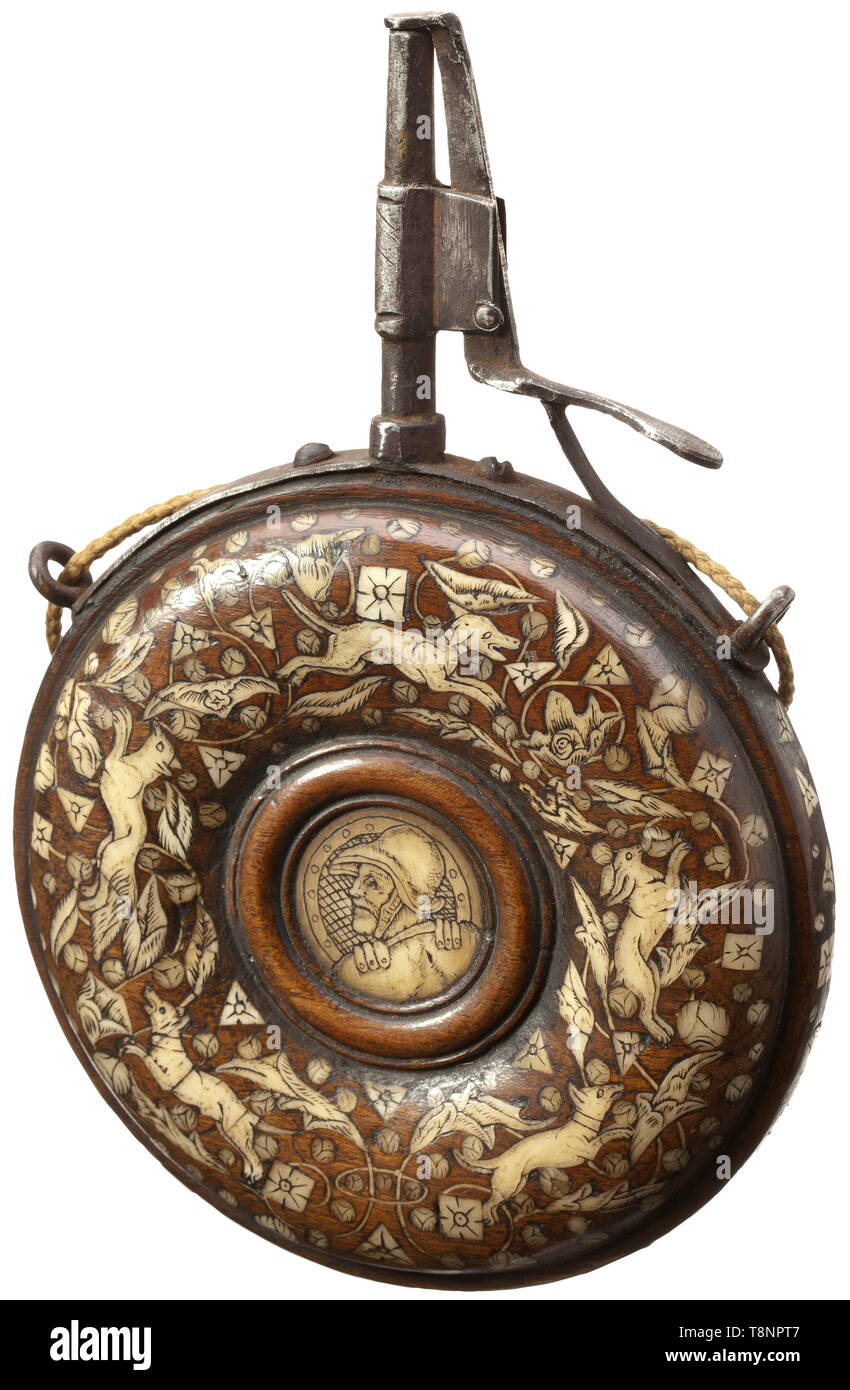 A German bone-inlaid powder flask, circa 1620 A circular wooden body with lavish bone inlays shaped like animals, blossoms and geometrical motifs on both sides. In the centre each with an inlaid bone disc with engraved warrior's head and coat of arms, respectively. Iron mounting (of later date) with conical spout and spring-loaded closure. Diameter 12.5 cm. historic, historical, handgun, firearm, fire arm, firearms, fire arms, gun, guns, hand weapon, hand weapons, object, objects, stills, 17th century, Additional-Rights-Clearance-Info-Not-Available Stock Photo