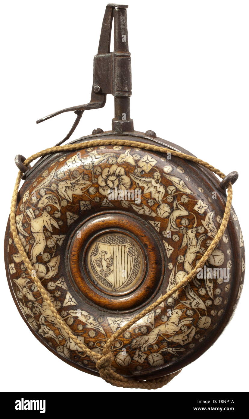 A German bone-inlaid powder flask, circa 1620 A circular wooden body with lavish bone inlays shaped like animals, blossoms and geometrical motifs on both sides. In the centre each with an inlaid bone disc with engraved warrior's head and coat of arms, respectively. Iron mounting (of later date) with conical spout and spring-loaded closure. Diameter 12.5 cm. historic, historical, handgun, firearm, fire arm, firearms, fire arms, gun, guns, hand weapon, hand weapons, object, objects, stills, 17th century, Additional-Rights-Clearance-Info-Not-Available Stock Photo