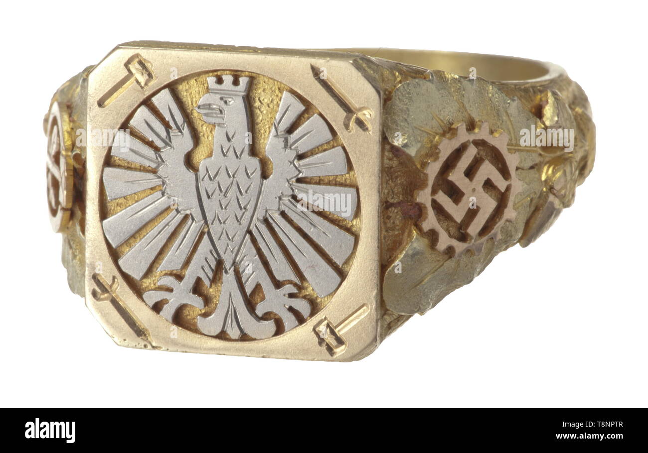 An honour ring of the 'City of German Crafts', Frankfurt on the Main Elaborate jeweller's work in various gold tones, the quadrangular plate on the obverse inlaid with a Frankurt eagle in white gold and alternately sword and hammer at the corners, the sides with separately applied golden oak leaves and acorns (some removed due to usage) and the emblems of the DAF and the Crafts Association, respectively, in red gold. The inner surface is engraved with 'Ehrengabe der Stadt des Deutschen Handwerks' and 'R.H.T. 1936' with fineness punch '585' and master's mark 'JF' for Frankfu, Editorial-Use-Only Stock Photo