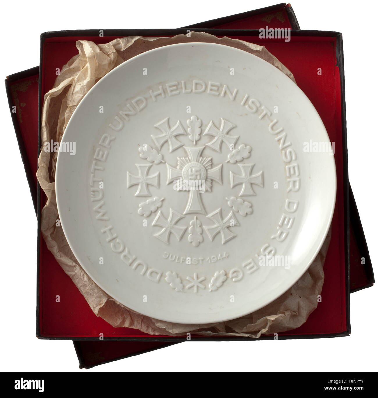 Yule Plate 1944 in original cardboard box White glazed porcelain. In the centre the Mother's Cross surrounded by Iron Crosses and Oak Leaves, raised inscription (tr.) 'Our victory is owing to mothers and heroes'. In the base inscription 'SS Yule Plate 1944' and factory mark, both in underglaze. Diameter 25 cm. In black gift cardboard box (only slight damages at the lid). Very rare. historic, historical, porcelain, chinaware, 20th century, Editorial-Use-Only Stock Photo