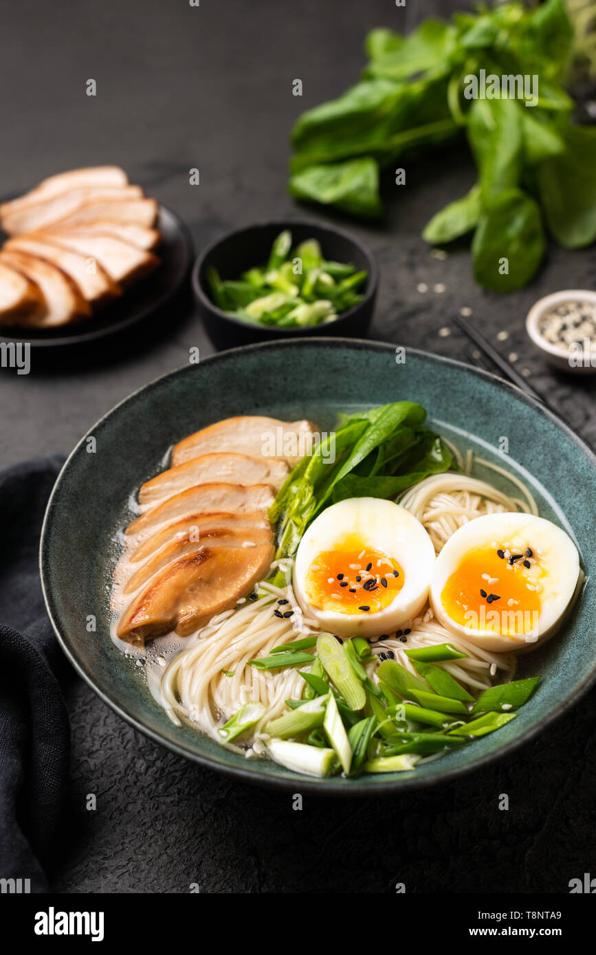 Japanese Ramen noodle soup with chicken on black background. Vertical orientation Stock Photo