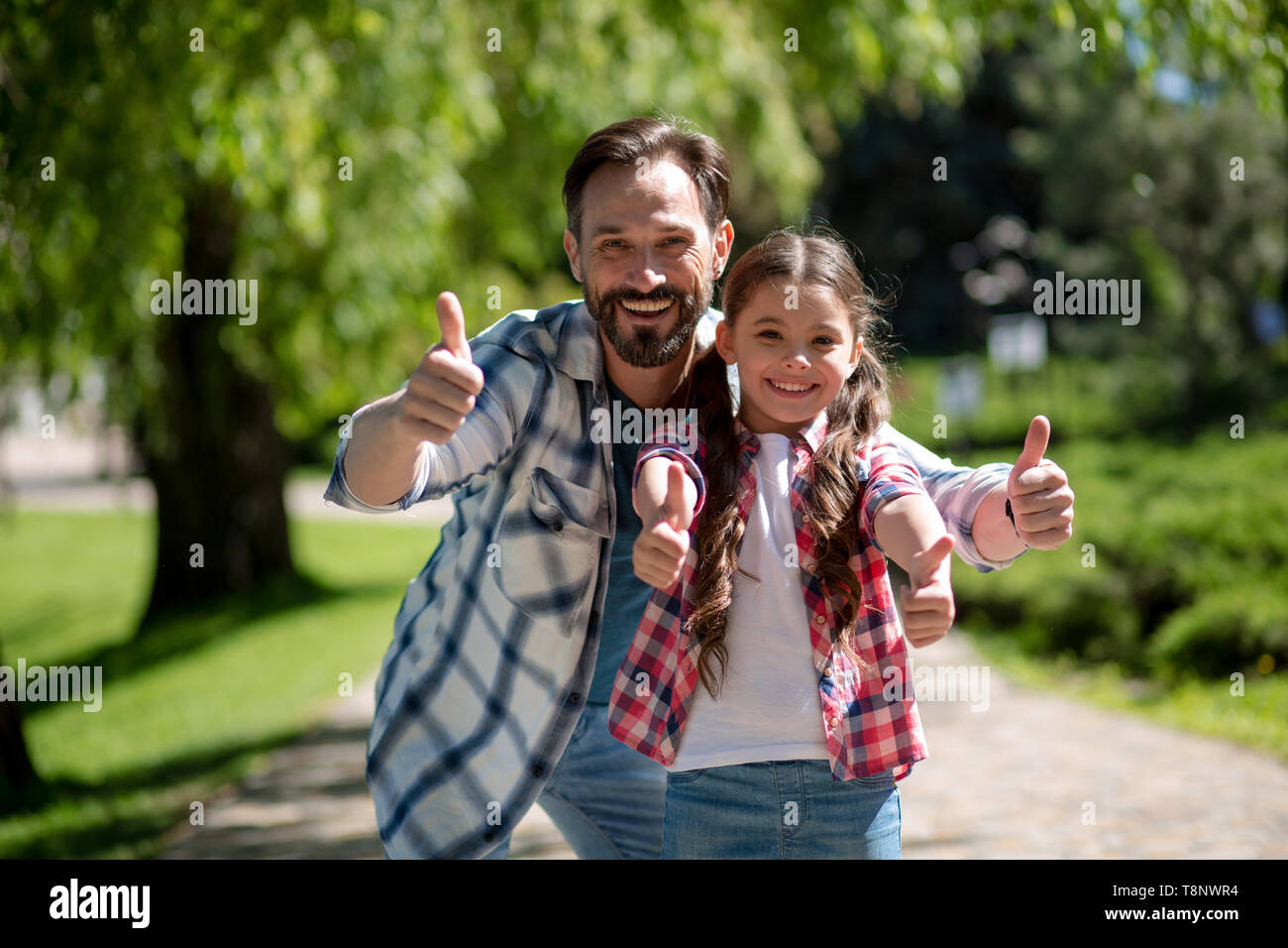 Happy Father And Daughter In City Park Showinh Together Thumb up. Happy Loving Family Concept. Stock Photo
