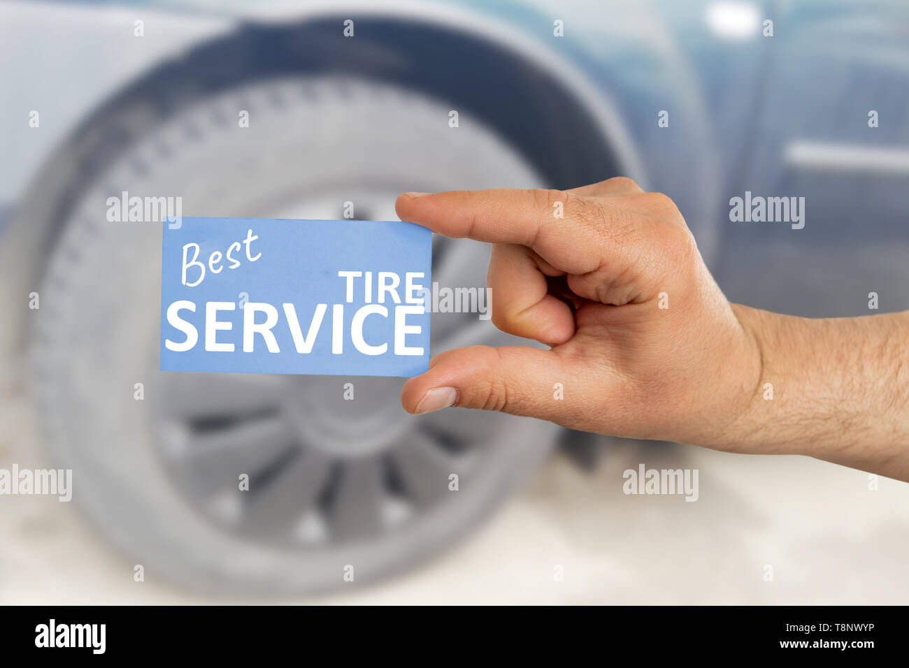 Mechanic man presenting blue best tire service card with text as